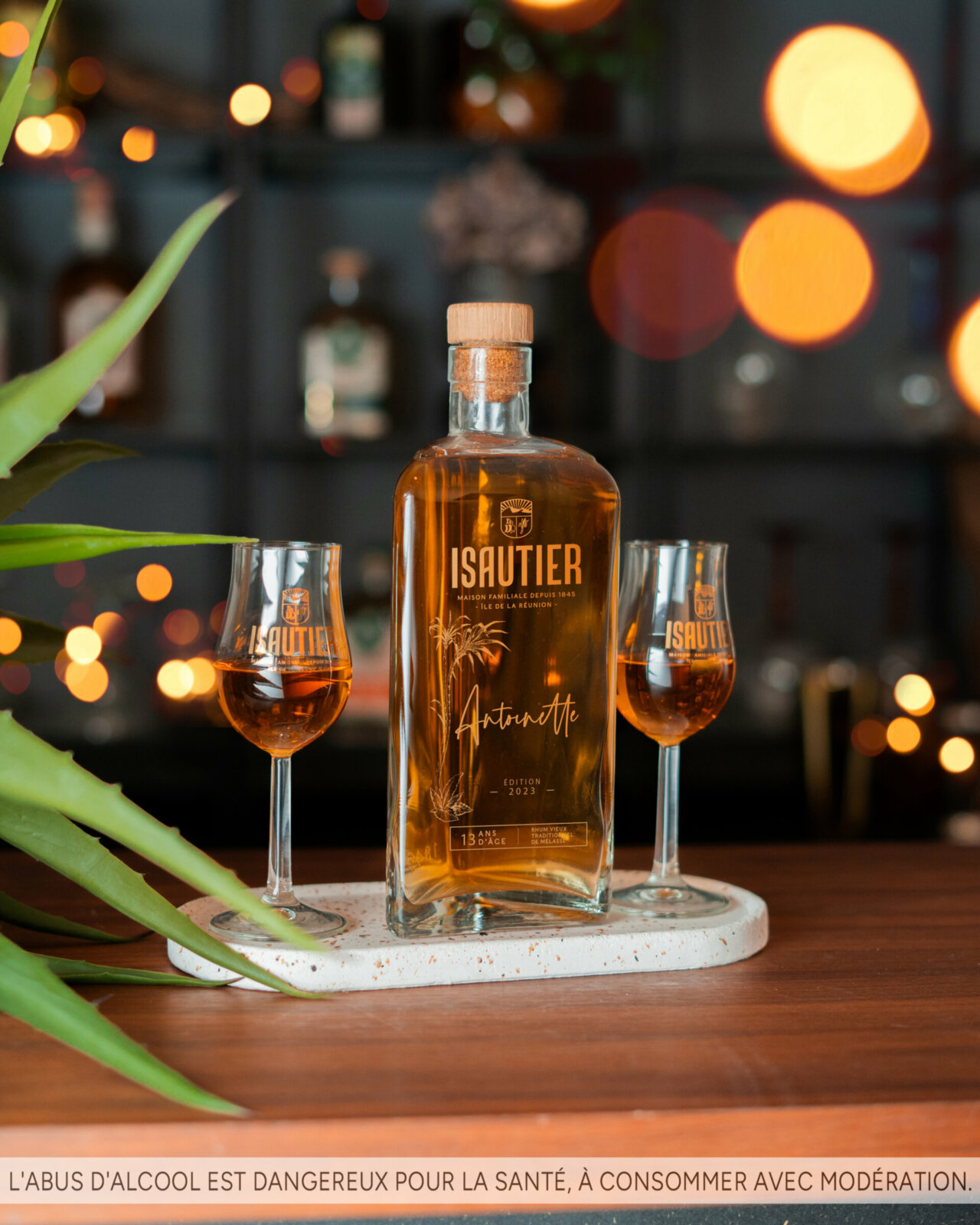 Bouteille de rhum Vieux Antoinette Isautier 58% posée sur un comptoir en bois.