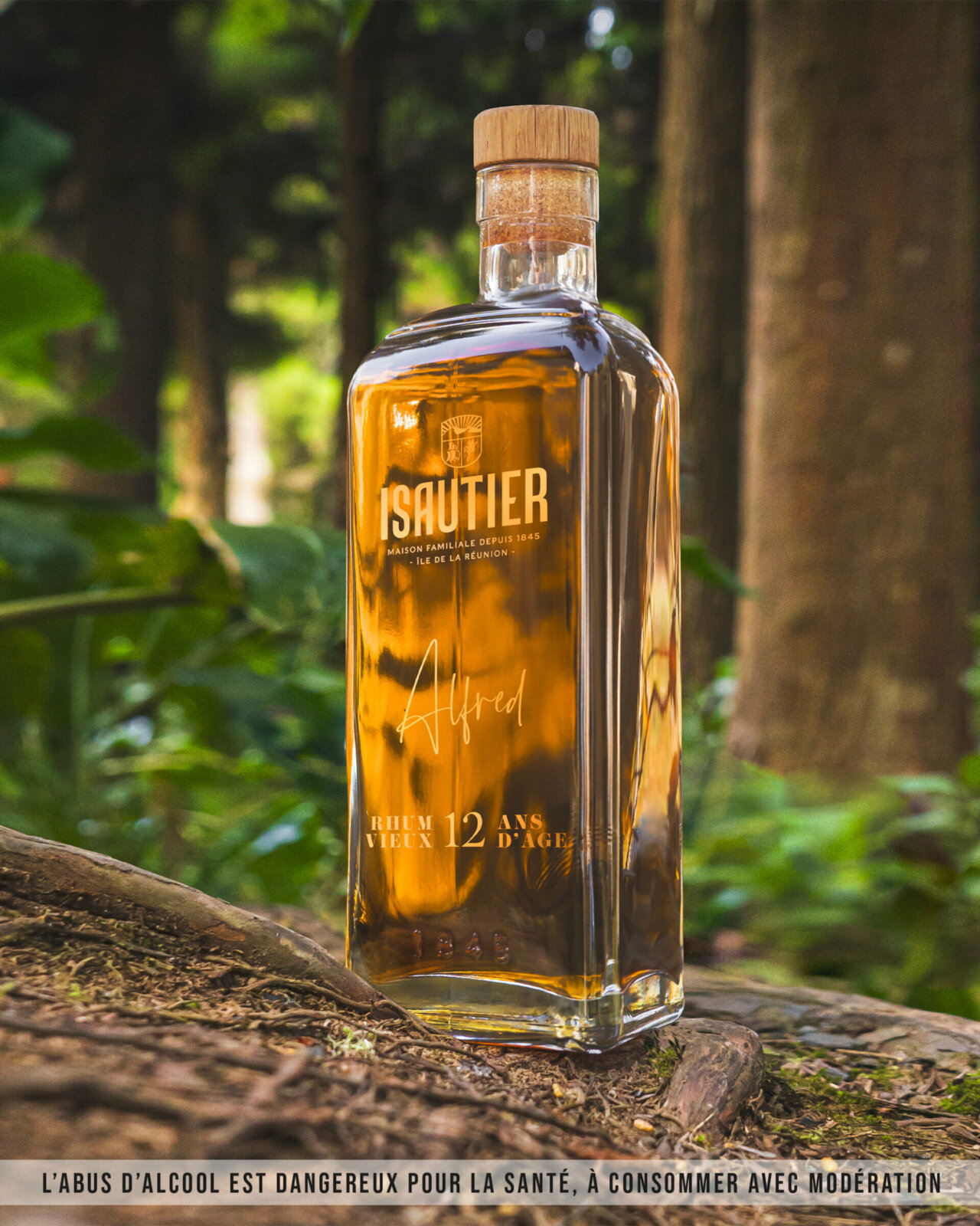 Bouteille de rhum Vieux Alfred Isautier 45% posée dans un décor tropical.
